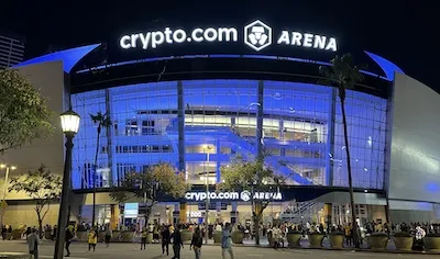 A large arena with a lit sign reading 'crypto.com ARENA' at night, surrounded by people.